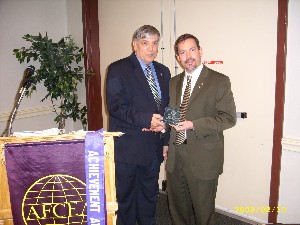 McElyea (r) receives a token of appreciation from Vic Budura, chapter vice president, programs.